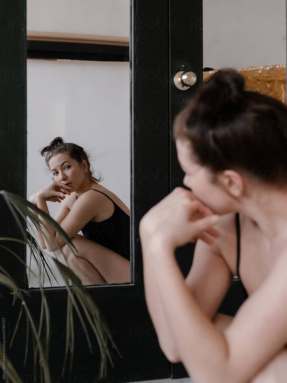 Woman looking in the mirror, struggling with body image. Learn more about this in Episode 033 of the Intuitively You Podcast - How to Dress Confidently at Any Body Size with Dacy Gillespie.