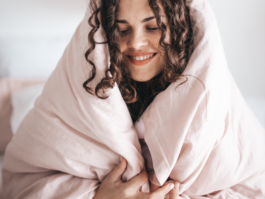 Woman wrapped up in a blanket feeling cozy - forgive yourself after a binge