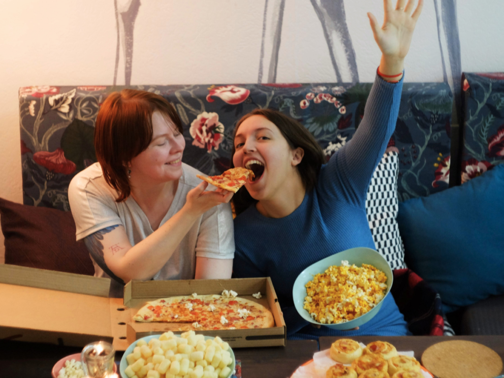 Two women eating snacks with the binge eating munchies