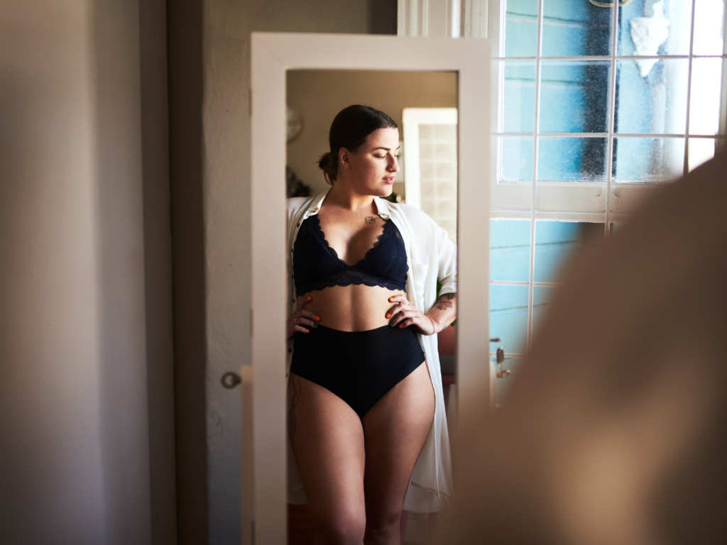 woman's reflection in the mirror in her underwear embracing body love on her intuitive eating journey