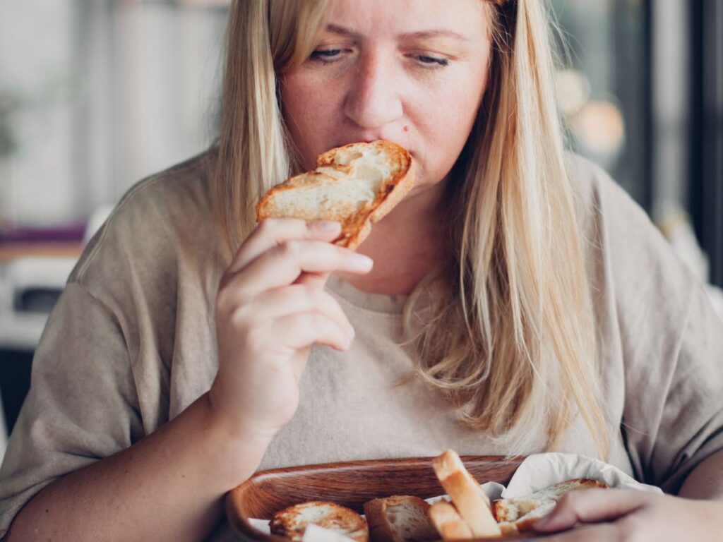 woman eating bread wondering why am I feeling guilty about food